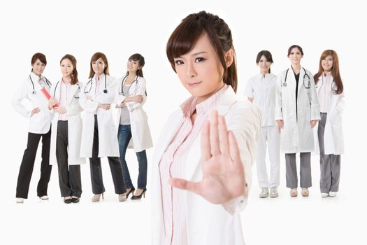 Asian doctor woman stand in front of her team and give you a stop sign, closeup portrait on white background.