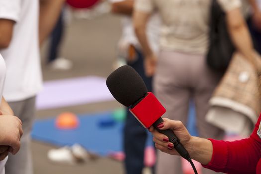 A journalist is making a interview with a microphone