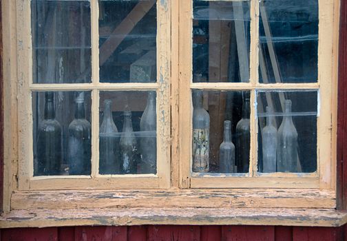 old window with bottle behind the glass