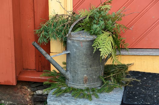 old watering can decorated with green on a staircase