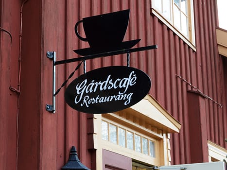 old cafe sign on an old red building