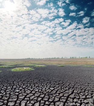 drought earth and hot sun in clouds over it