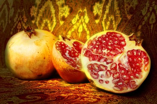Pieces and grains of ripe pomegranate on old fabric background  still life