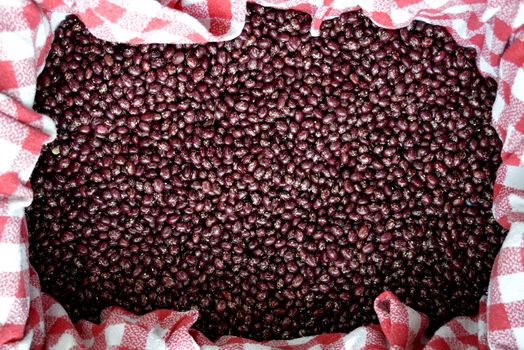 harvest of red beans on a tablecloth drying in the sun