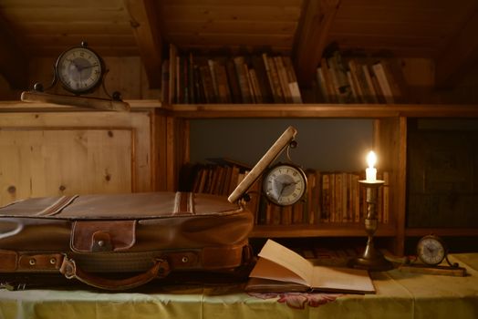 clocks floating above a suitcase and travel books, time concept