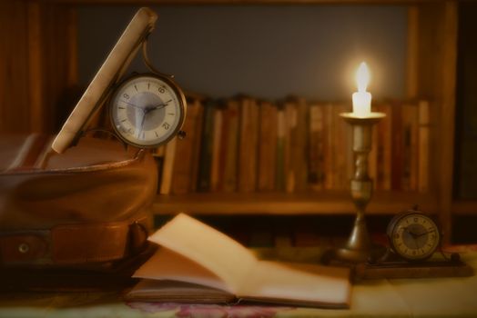 ree time to travel and read, watch old book and suitcase illuminated by candlelight