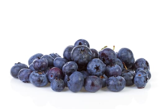 Pile of black currant berries in closeup over white background