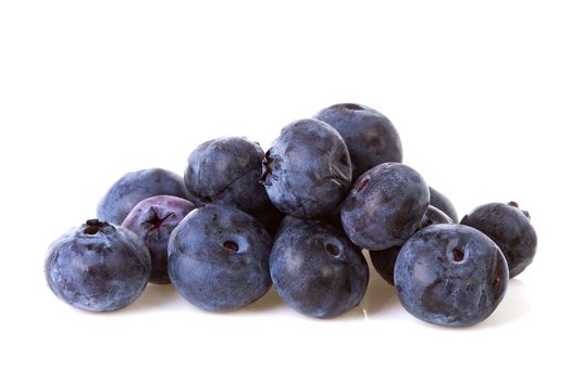 Pile of black currant berries in closeup over white background