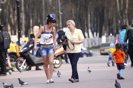 Two women with a camera photographed street of the city in the summer