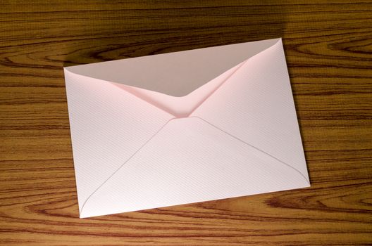soft pink envelope on wooden background