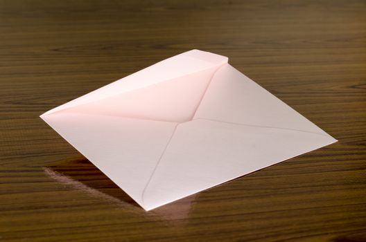 soft pink envelope on wooden background