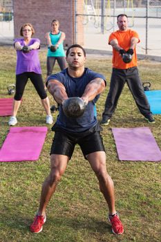 Strong man with tattoo leading kettle bell weight training