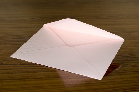 soft pink envelope on wooden background