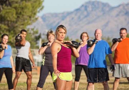Serious woman with people exercising in outdoor boot camp