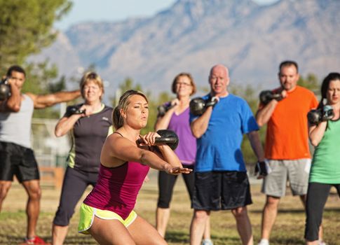 Mixed group of people working out near mountains