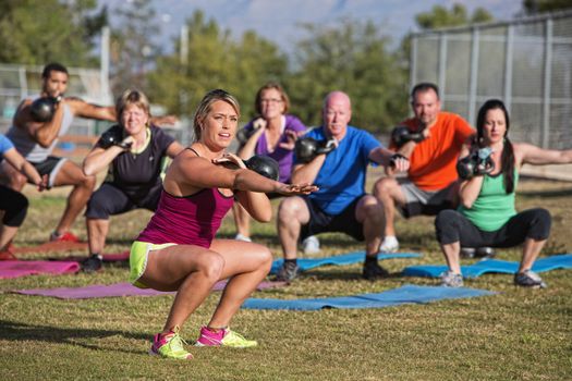 Mixed group of people doing a boot camp exercise class