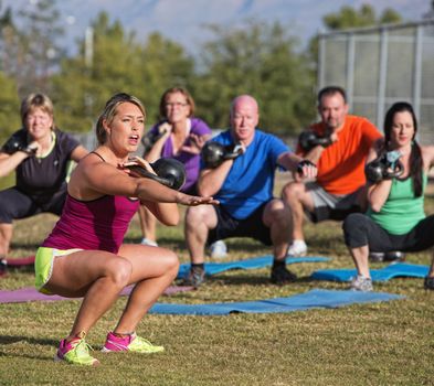 Boot camp fitness trainer yelling during squat exercises