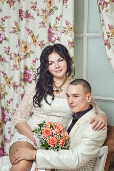 Attractive young couple hugging each other in room