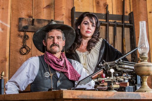 Gruff Cowboy Poses With A Rifle And Stern Saloon Girl