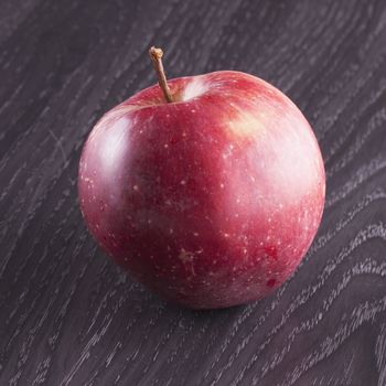 Red apple over wooden background, close up