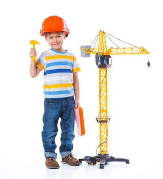 Little builder. Boy in a helmet plays in the builder with tools. Isolated over white.