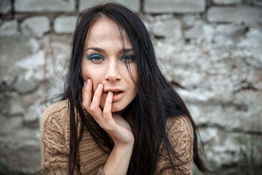 Portrait of a girl against old brick wall