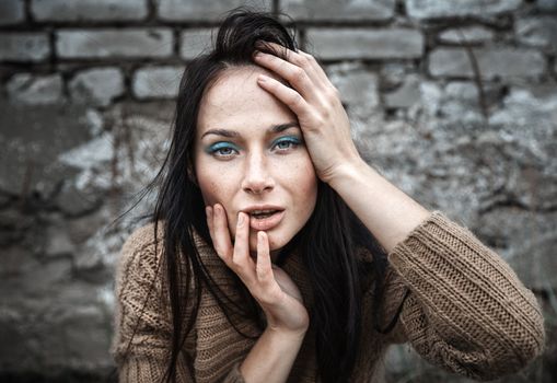 Portrait of a girl against old brick wall