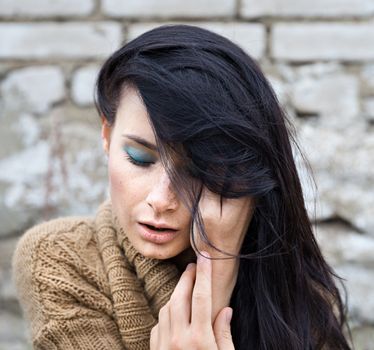 Portrait of a girl against old brick wall