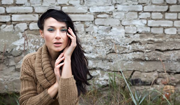 Portrait of a girl against old brick wall