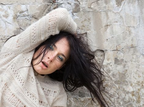 Portrait of a girl against old concrete wall