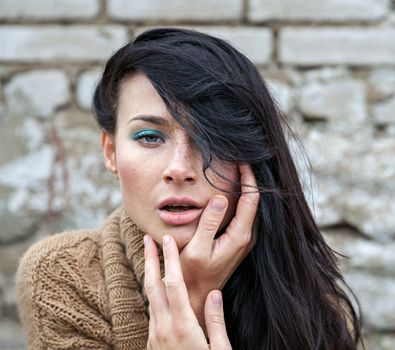 Portrait of a girl against old brick wall