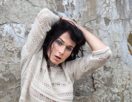 Portrait of a girl against old concrete wall