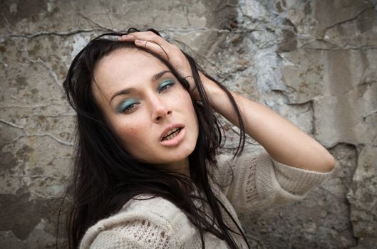 Portrait of a girl against old concrete wall