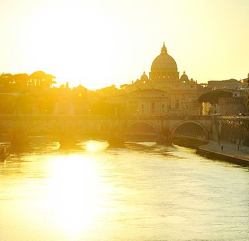  View of Tiber and St. Peter's cathedral at sunset in Rome 