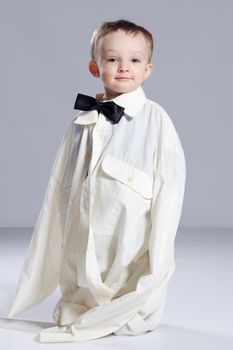 Boy toddler businessman, standing dressed in grown-shirt with bow tie