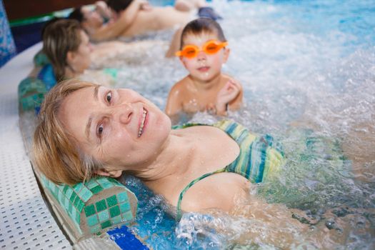 In aquapark. Smiling beautiful woman relaxing in pool.