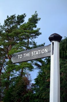 Wood sign post informing of direction of the train station. Image taken in Sussex, England.