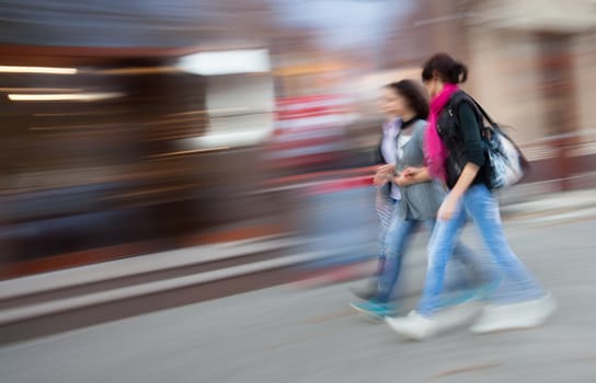 Abstract image of young people group going along the street. Intentional motion blur