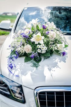 White wedding car with flower bouquet on the cowl