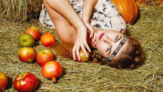 Attractive young rural girl in the hayloft after harvest festival