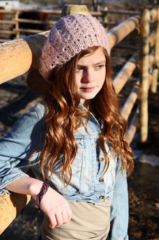 Teen girl outdoors on farm with horses 