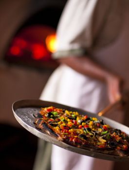 Traditional pizza baked with oven in the background