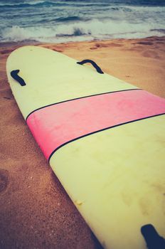 A Vintage Surf Board On A Deserted Wild Beach In Hawaii