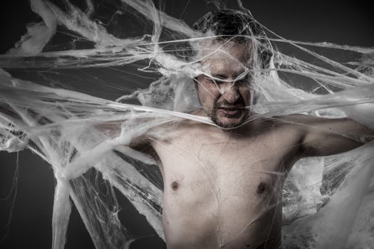 network.man tangled in huge white spider web