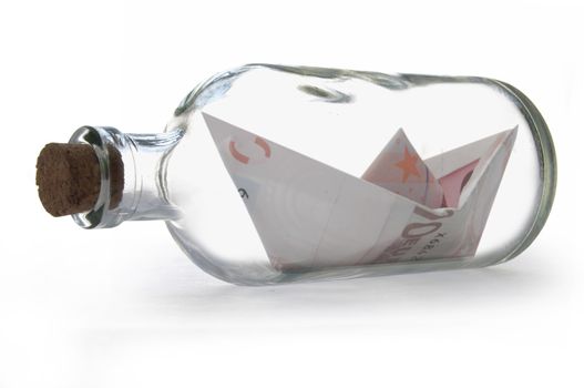 Paper boat made from Euro banknotes inside a message bottle 