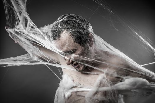 Spiderweb.man tangled in huge white spider web