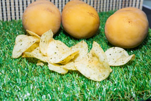 Fried potatoes, cut into pieces, mixed spices.on green grass