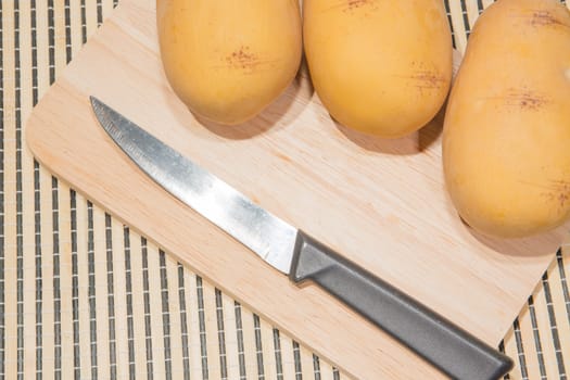 Potato knife on a wooden floor.