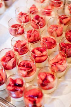 Cream desserts with strawberry in a row