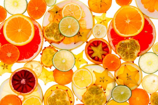 Healthy vibrant tropical fruit and citrus background of sliced orange, lemon, lime, a variety of grapefruit, carambola or star fruit and kiwano or horned melon, symbolic of vitality and health